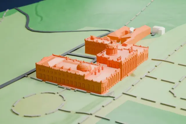 A white 3D print of Castle Howard, a long domed house with projecting wings, set among formal garden paths, lawns and a few outbuildings.