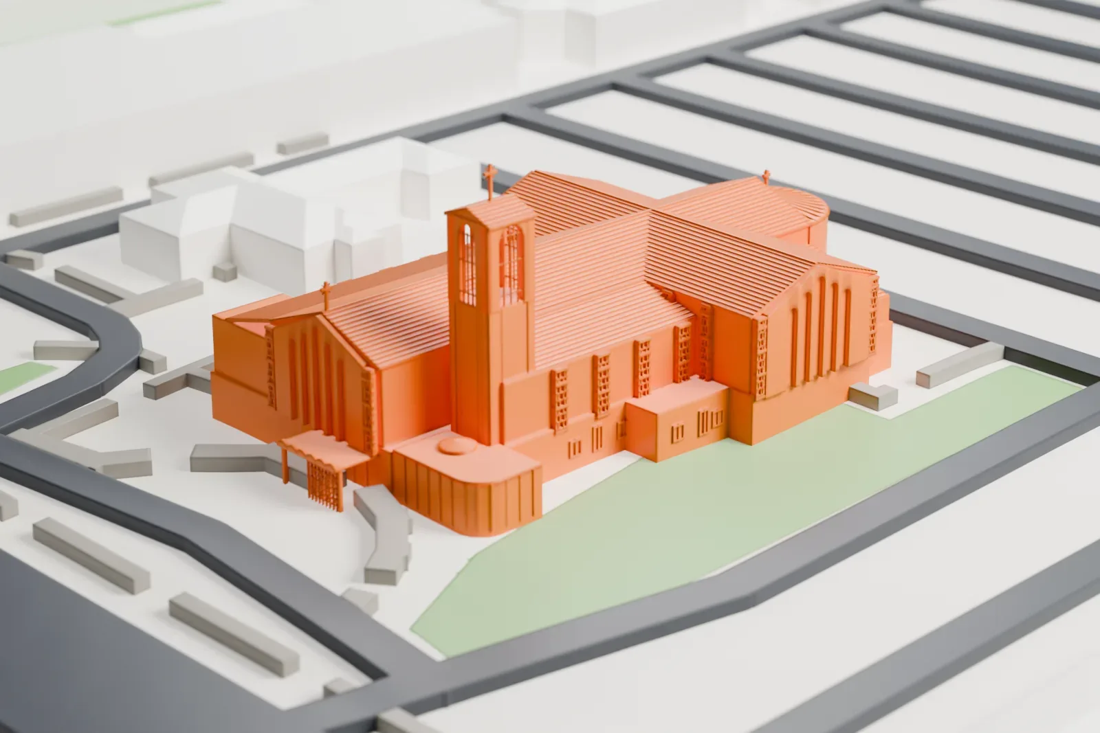 A white 3D print of the Cathedral of Saints Simon and Jude, a cross-shaped church with a bell tower, among streets, lawns and low buildings.