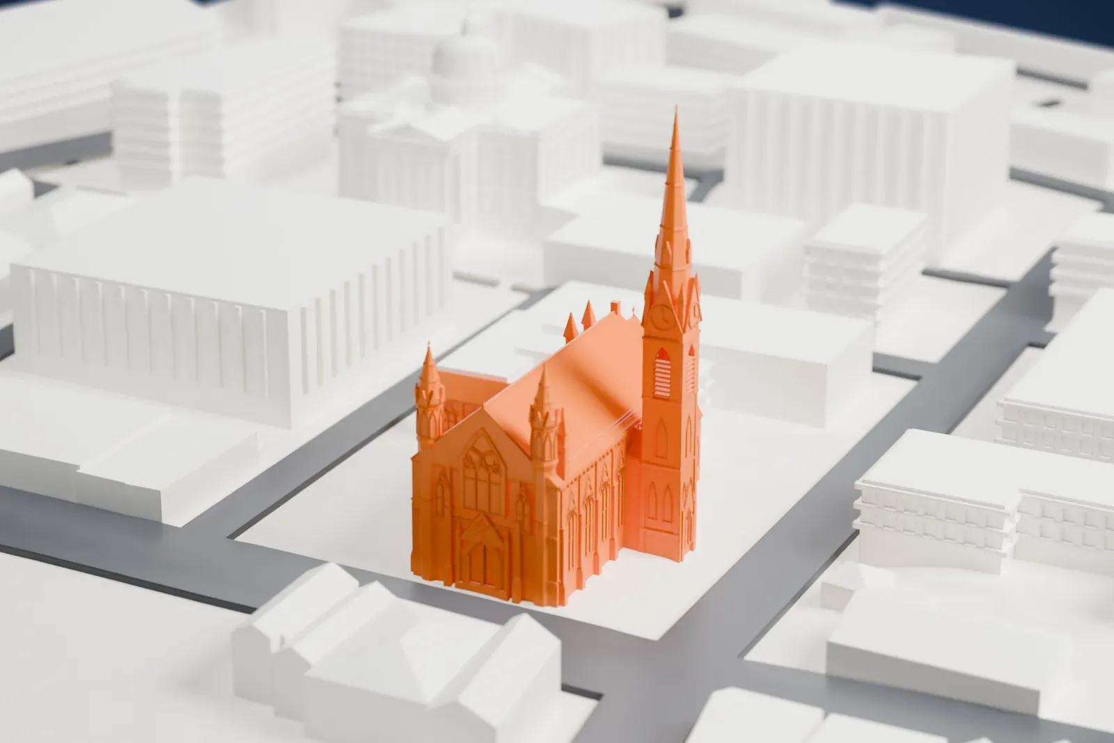 A white 3D print of the Cathedral of St. John the Baptist, a Gothic-style church with a very tall spire and a long gabled roof, among streets and mid-rise buildings.