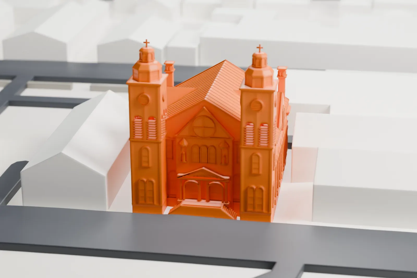 A white 3D print of the Cathedral of St. Michael the Archangel, a church with two domed towers and a rounded apse, among low buildings and streets.
