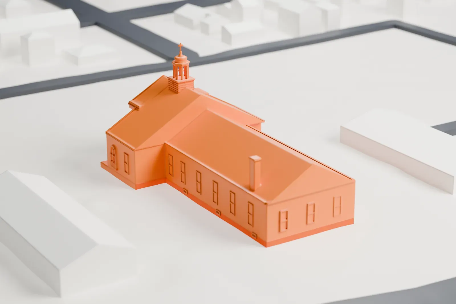 A white 3D print of the Cathedral of St Vincent de Paul, a church with a columned front, a cupola on the roof and a long side wing, among low buildings and streets.