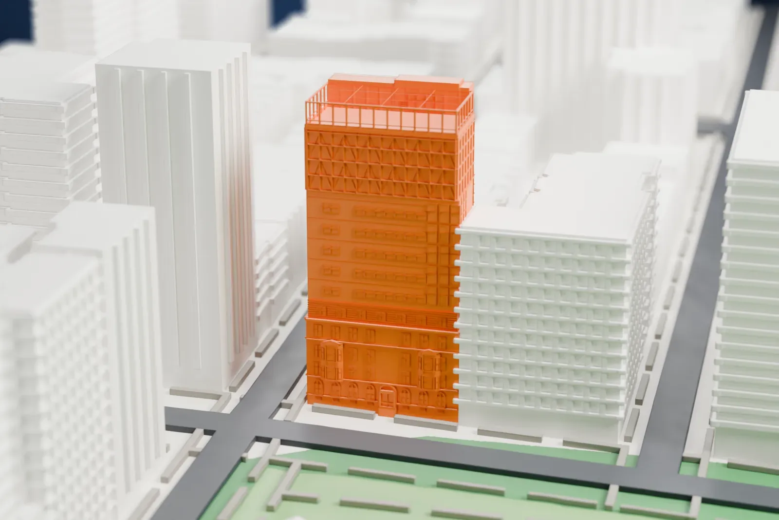 A white 3D print of the Chapin School, a rectangular block among surrounding buildings beside a green park and the river.
