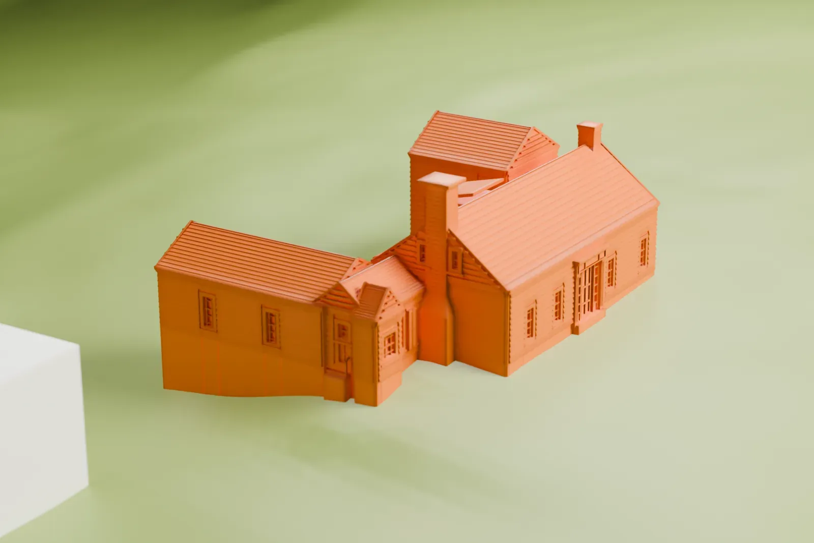 A white 3D print of the Checkerboard Inn, a gabled house with two wings and tall chimneys, standing alone on open green land.