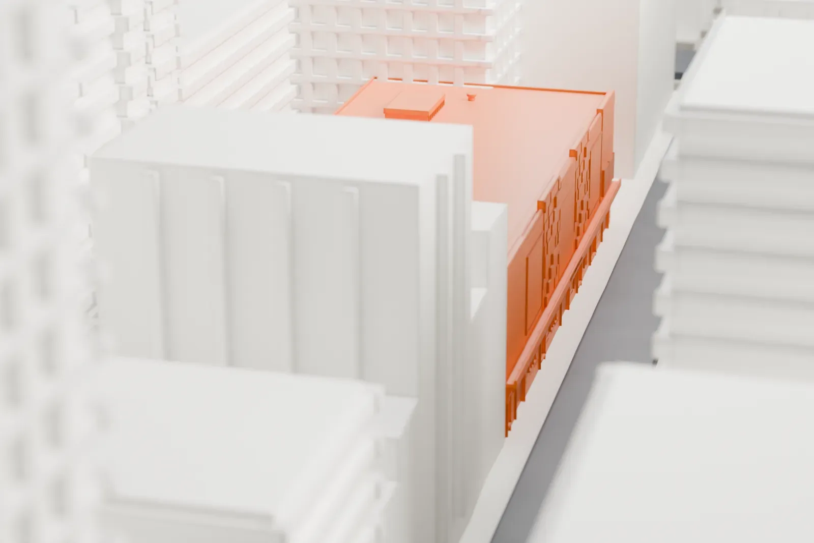 A white 3D print of Chelsea Studios, a low, flat-roofed building with a small rooftop structure, surrounded by much taller buildings.