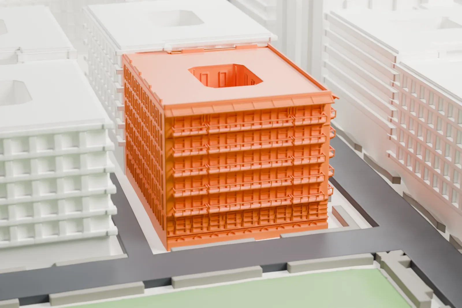 A white 3D print of the Cherokee Apartments, a square block with a courtyard opening in its roof, beside a strip of green and a street among neighboring buildings.