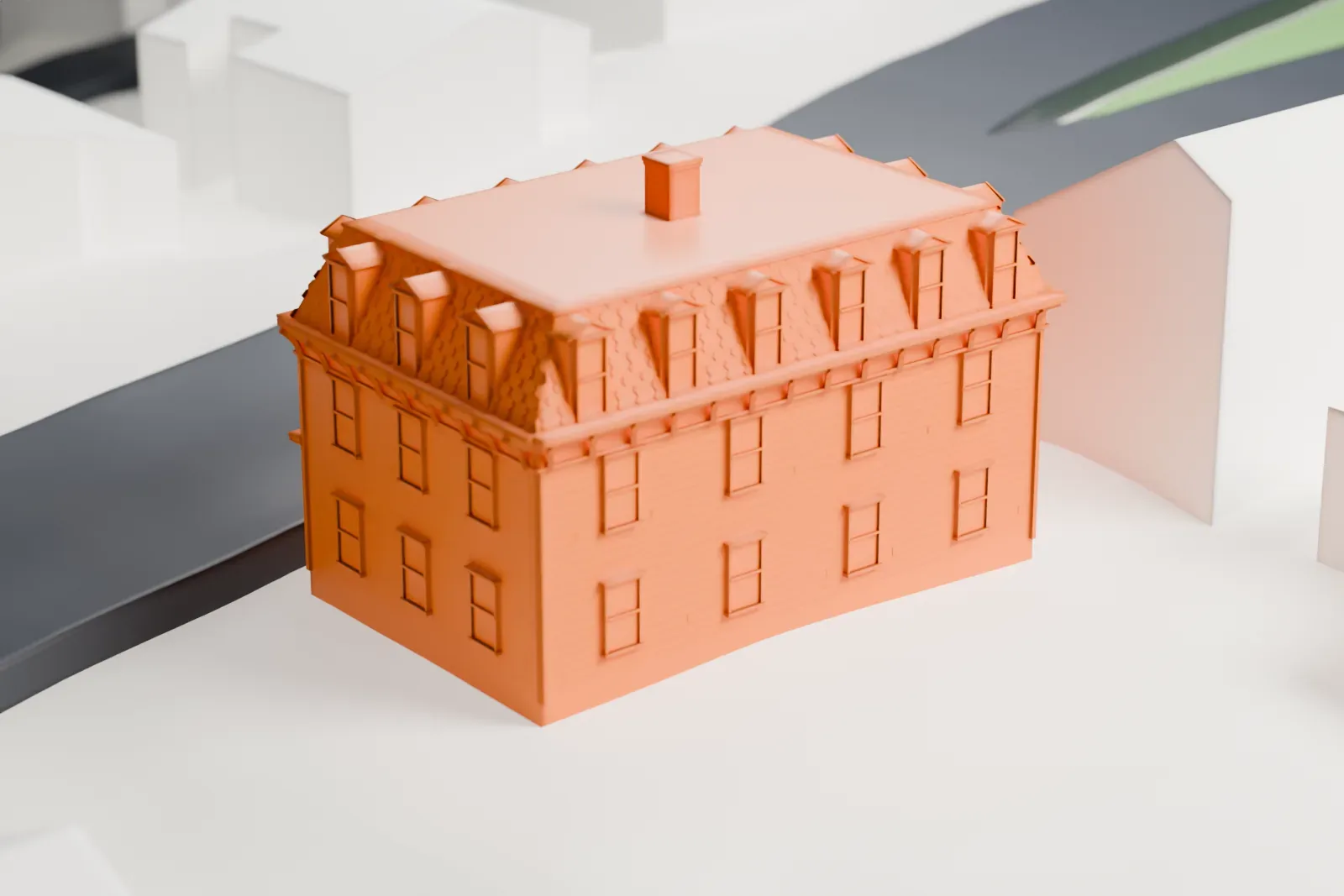 A white 3D print of a three-story building with a mansard roof and dormers, among streets and nearby houses.