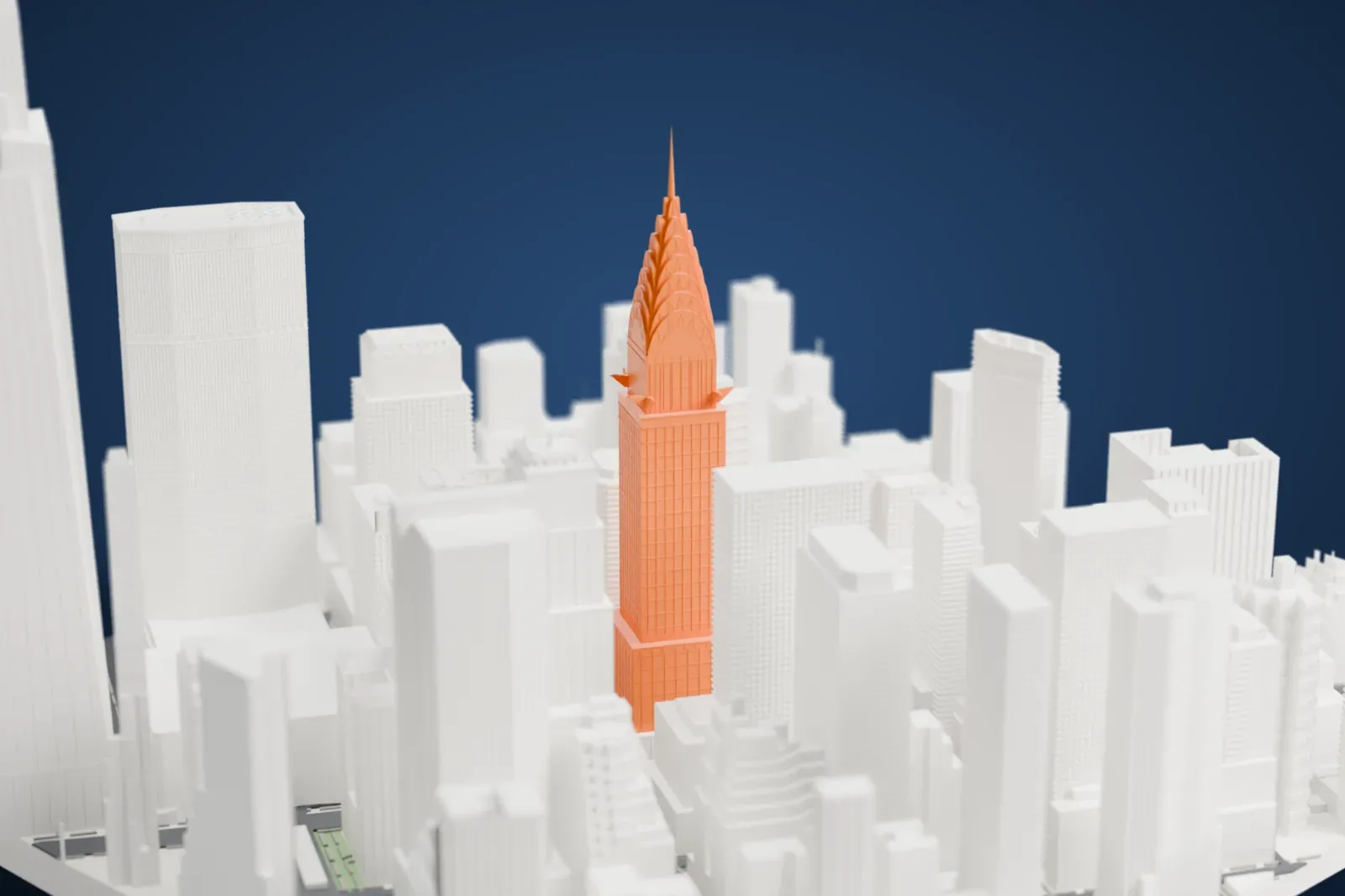 A white 3D print of the Chrysler Building, its tiered crown and needle rising above the dense towers of Midtown Manhattan.