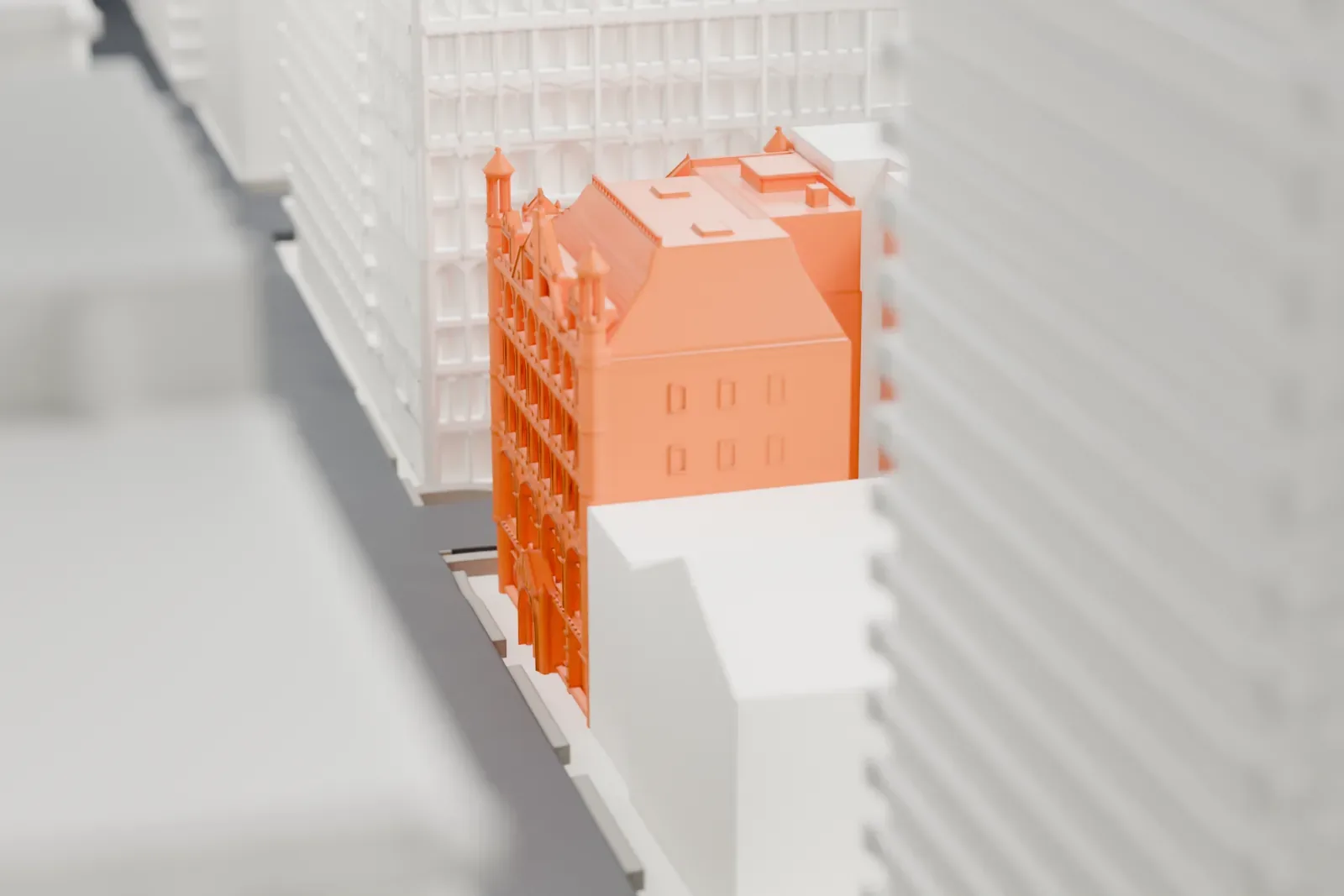 A white 3D print of Church Missions House, a low building with small corner turrets and steep roofs, almost hidden between tall buildings.