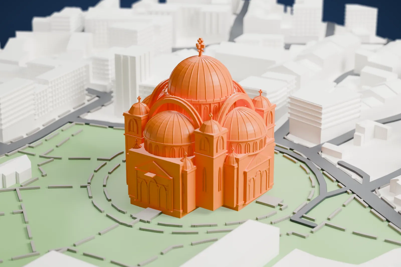 A white 3D print of the Church of Saint Sava, a large church with a ribbed central dome, four smaller domes and tiny corner domes, standing on a green lawn with paths and surrounded by streets and buildings.