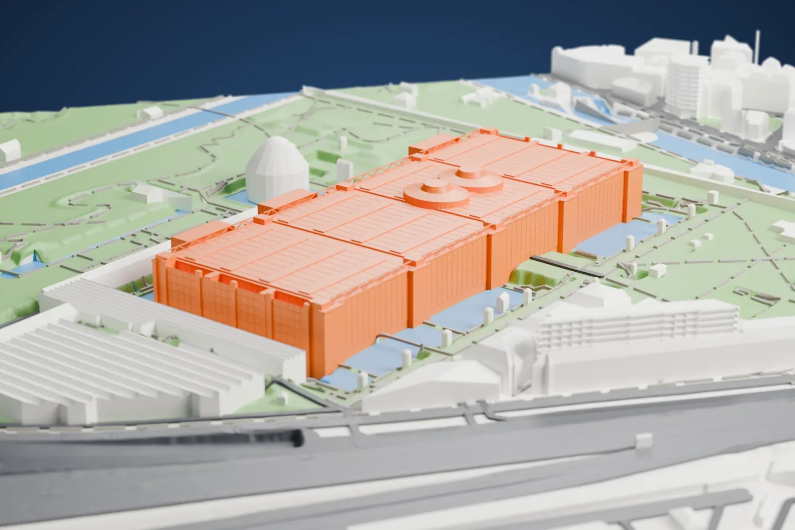 A white 3D print of the Cité des Sciences et de l'Industrie with a broad detailed roof, surrounded by parkland, waterways, paths, and nearby buildings.