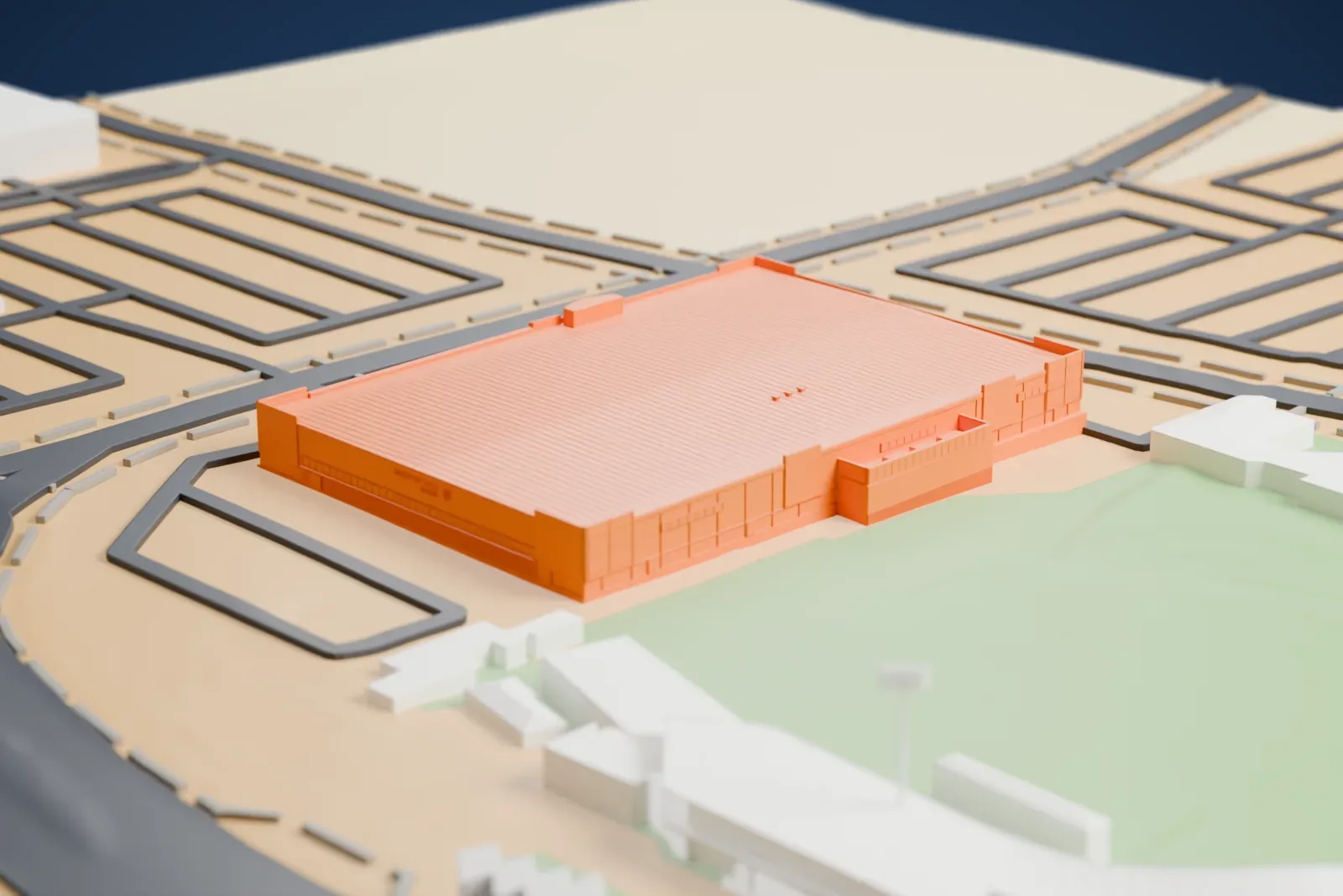 A white 3D print of City National Arena, a wide, low rectangular building with a flat patterned roof, beside a green field, a ballpark and roads.