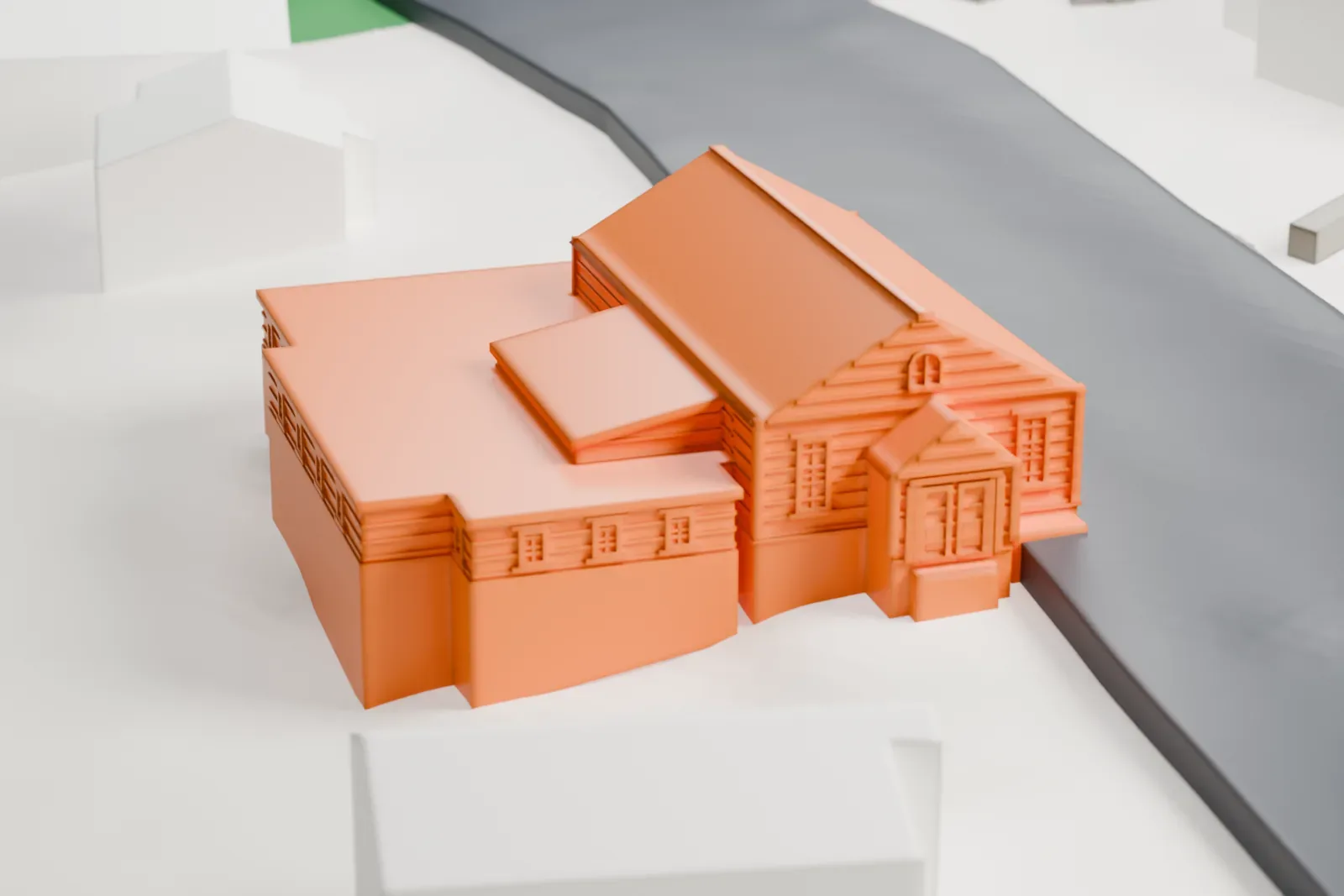 A white 3D print of the Civil War Drill Hall and Armory, a gabled hall with low wings, beside a road with houses and lawn nearby.