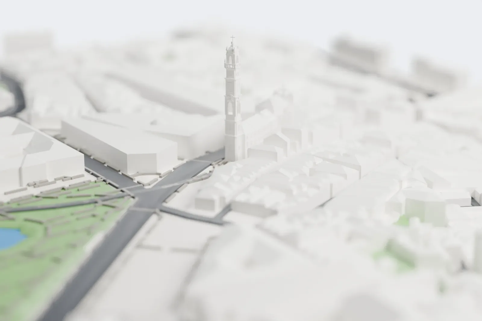 A white 3D print of the Clérigos Church, a Baroque church with a tall, slender bell tower, surrounded by closely packed pitched-roof buildings, with a park and pond nearby.