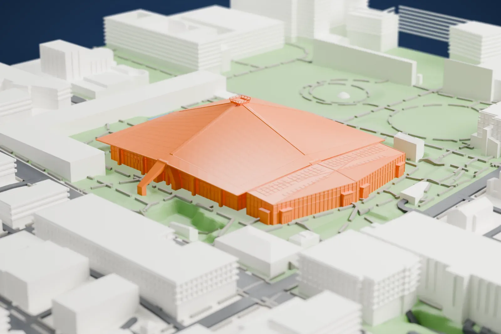 A white 3D print of Climate Pledge Arena, a broad sloping roof with angled arms at its corners, set among green park paths with streets and buildings around it.