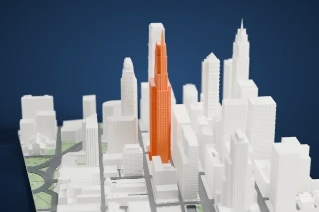 A white 3D print of the Comcast Technology Center, a tall stepped tower with a slim spire at its crown, rising above a dense cluster of other downtown towers.