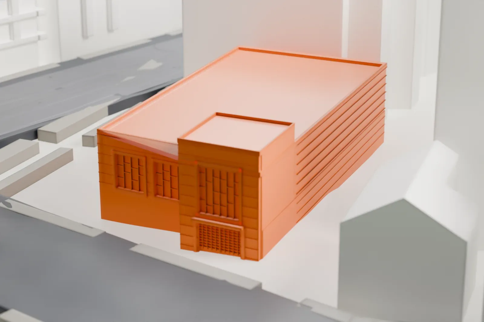 A white 3D print of Congregation Beth Jacob Ohev Sholom, a low brick synagogue with a flat roof and a small raised corner block, beside a road with taller buildings behind it.