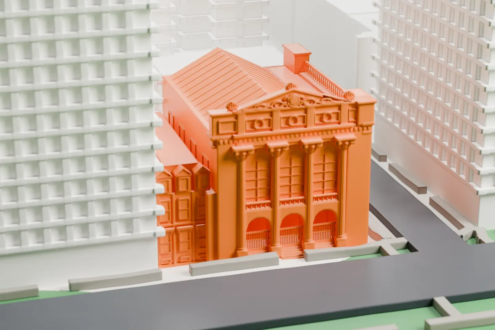 A white 3D print of Congregation Shearith Israel, a small building on the edge of a large green park, with taller buildings alongside it.