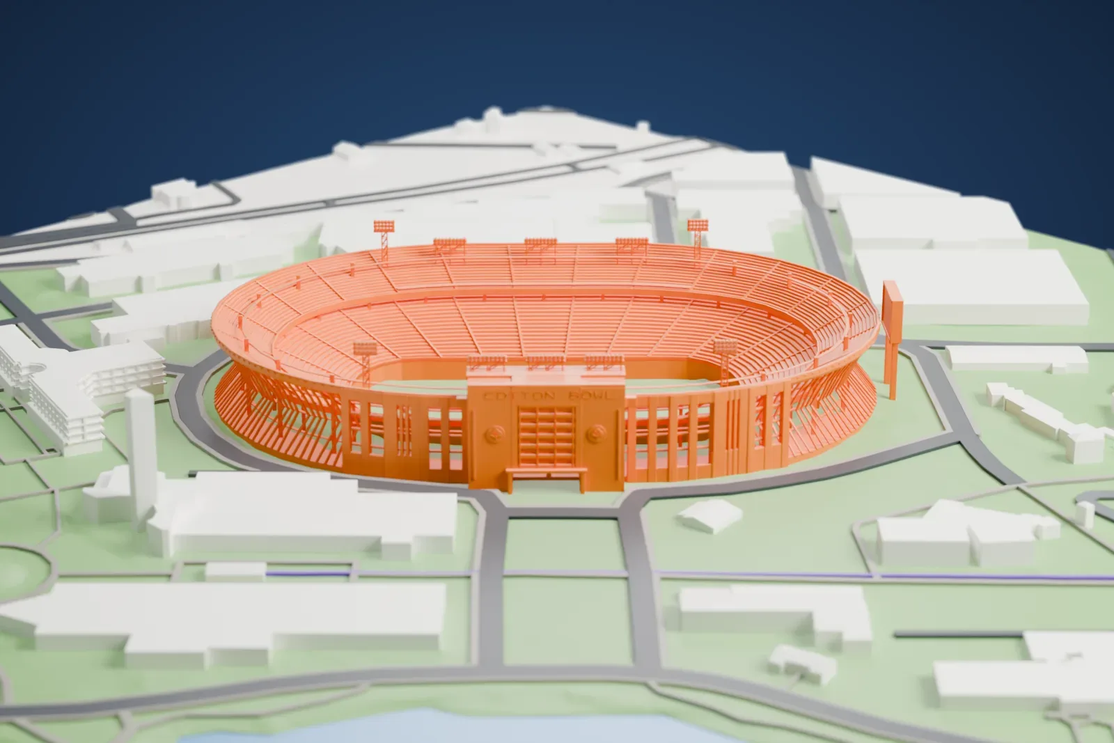 A white 3D print of the Cotton Bowl, an open two-tier stadium bowl with a central entrance facade, among the surrounding buildings of Fair Park.