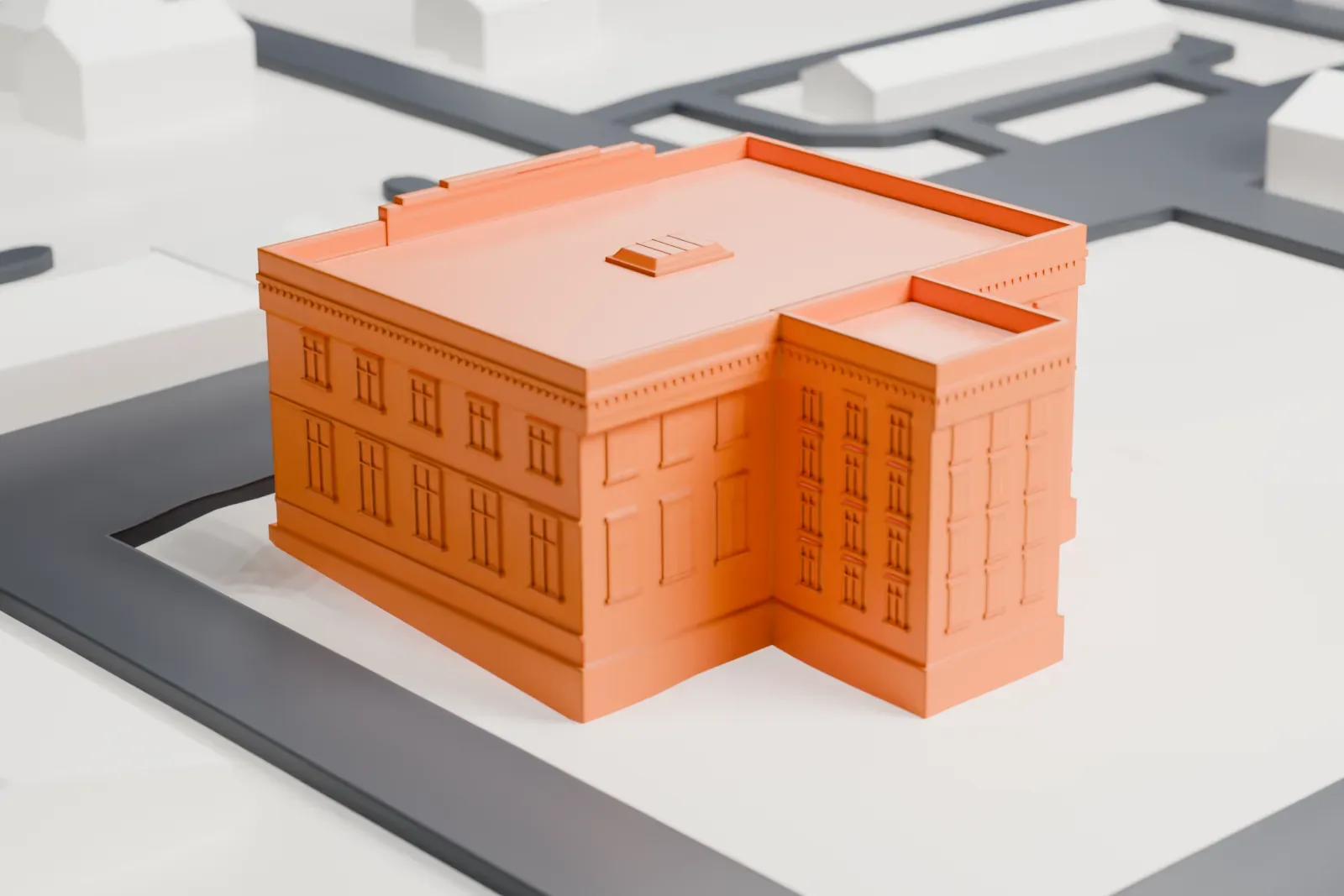 A white 3D print of the Danforth Memorial Library, a two-story flat-roofed building with a four-column front, standing alone on a block between streets.