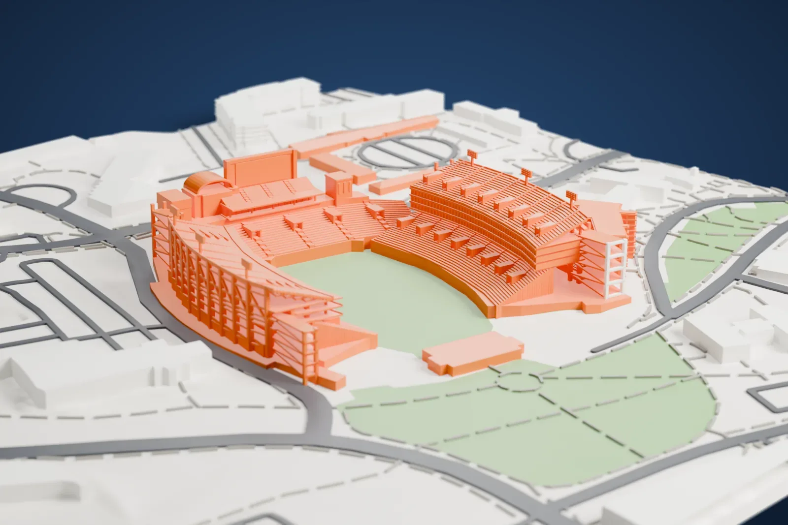 A white 3D print of Davis Wade Stadium, a football stadium with tall double-decked stands along both sides and curved stands at the ends, beside green lawns, roads and low buildings.