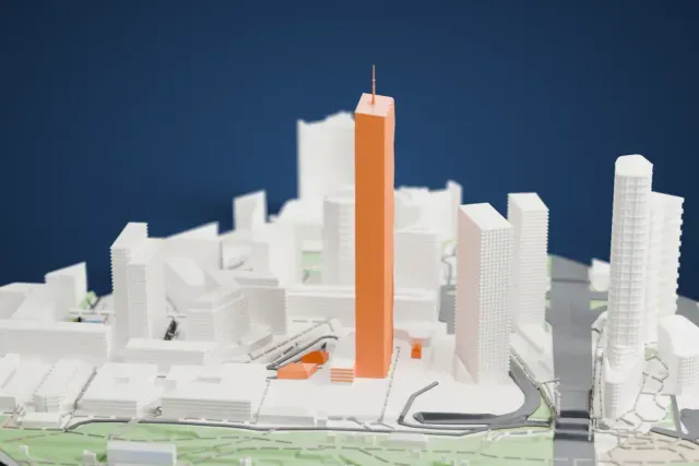 A white 3D print of the DC Tower 1 model in Vienna, with the streets around it.