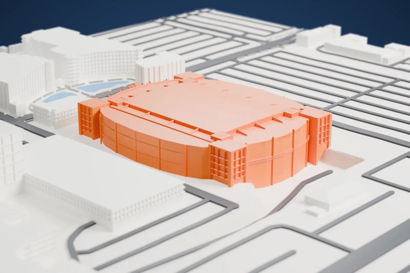 A white 3D print of Desert Diamond Arena, an oval arena with a broad flat roof and square corner towers, surrounded by roads and large buildings.