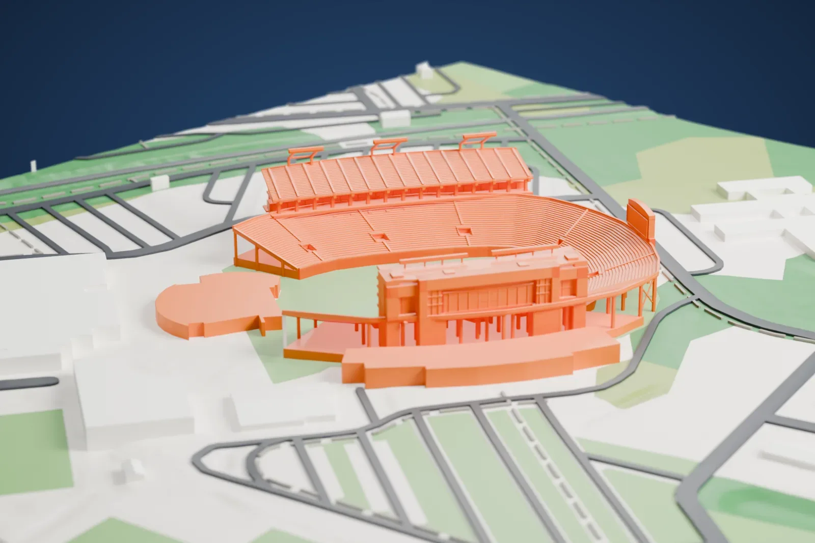 A white 3D print of Dowdy–Ficklen Stadium, a horseshoe bowl of tiered seating around a green field, with parking lots, roads and green areas around it.