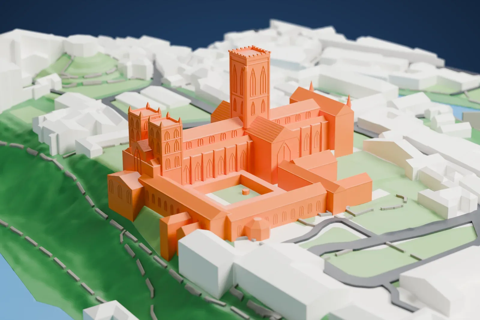 A white 3D print of Durham Cathedral, a long church with a square central tower and two western towers beside a square cloister court, on a green hill with water curving around it and buildings nearby.