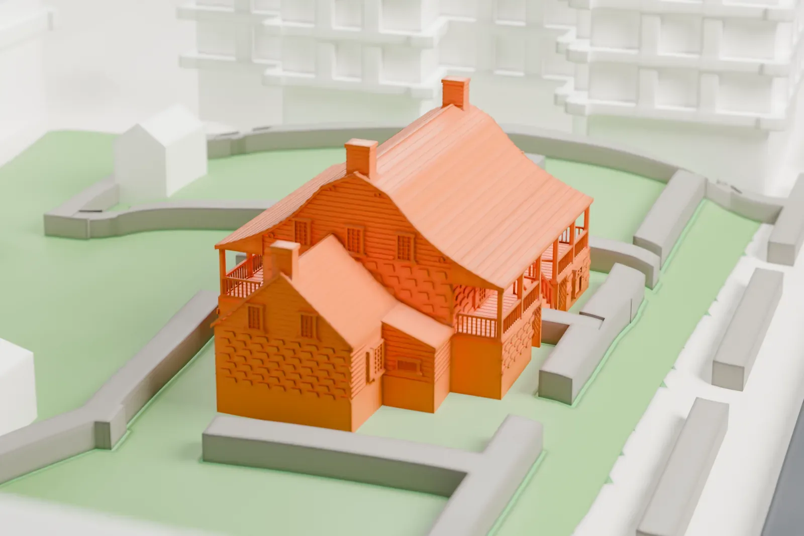 A white 3D print of the Dyckman House, a gambrel-roofed farmhouse with porches and chimneys, on a small green lot beside a road and taller buildings.