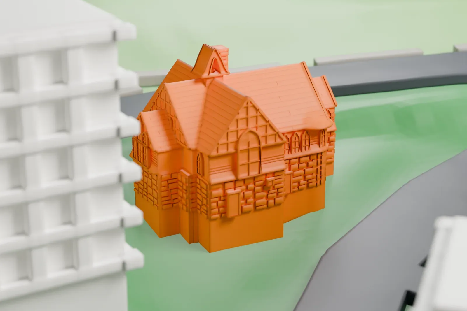 A white 3D print of Edgehill Church, a church with many steep gables and a chimney, standing on green ground beside a curving road.