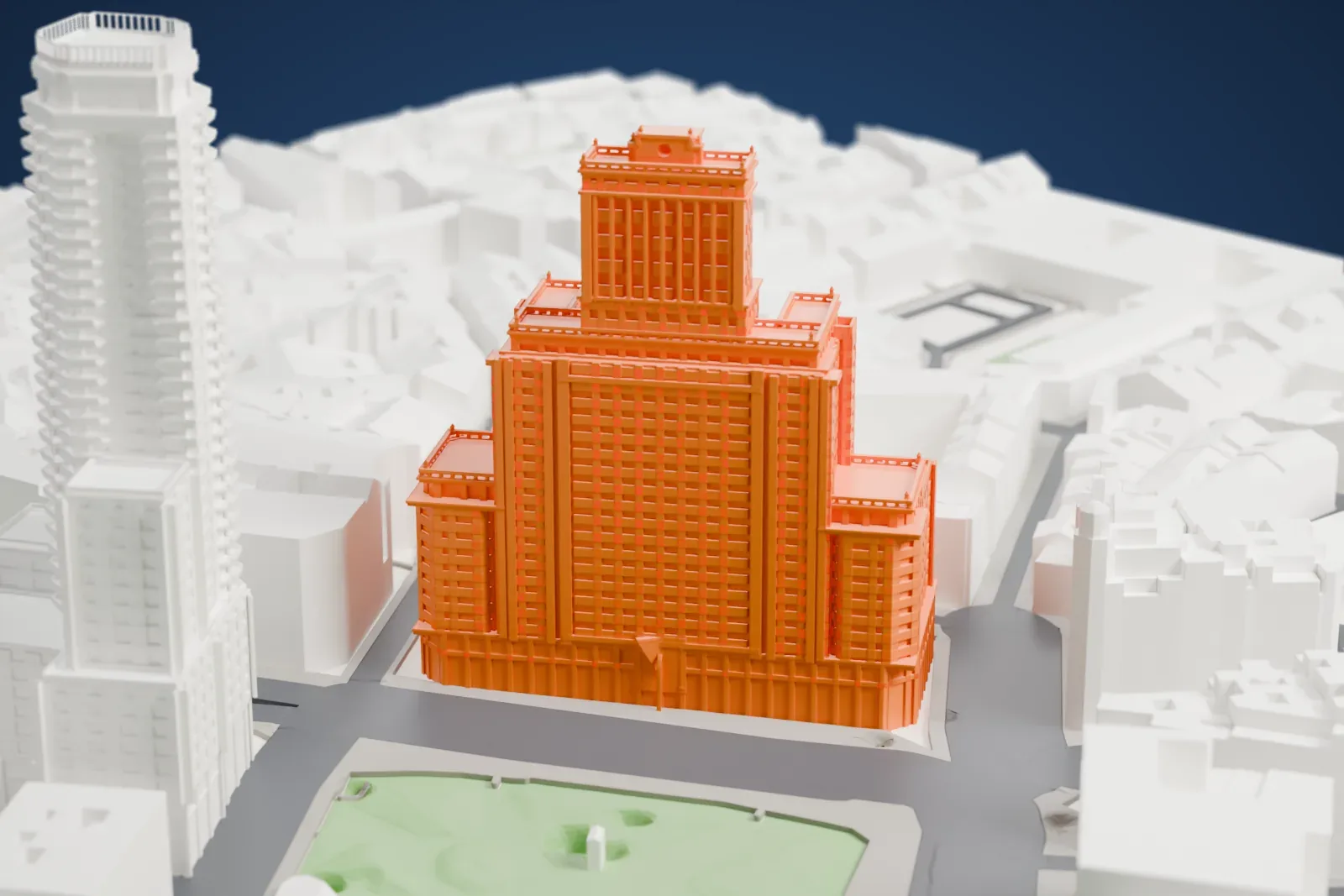 A white 3D print of the Edificio España on Plaza de España in Madrid, among the surrounding streets and buildings.
