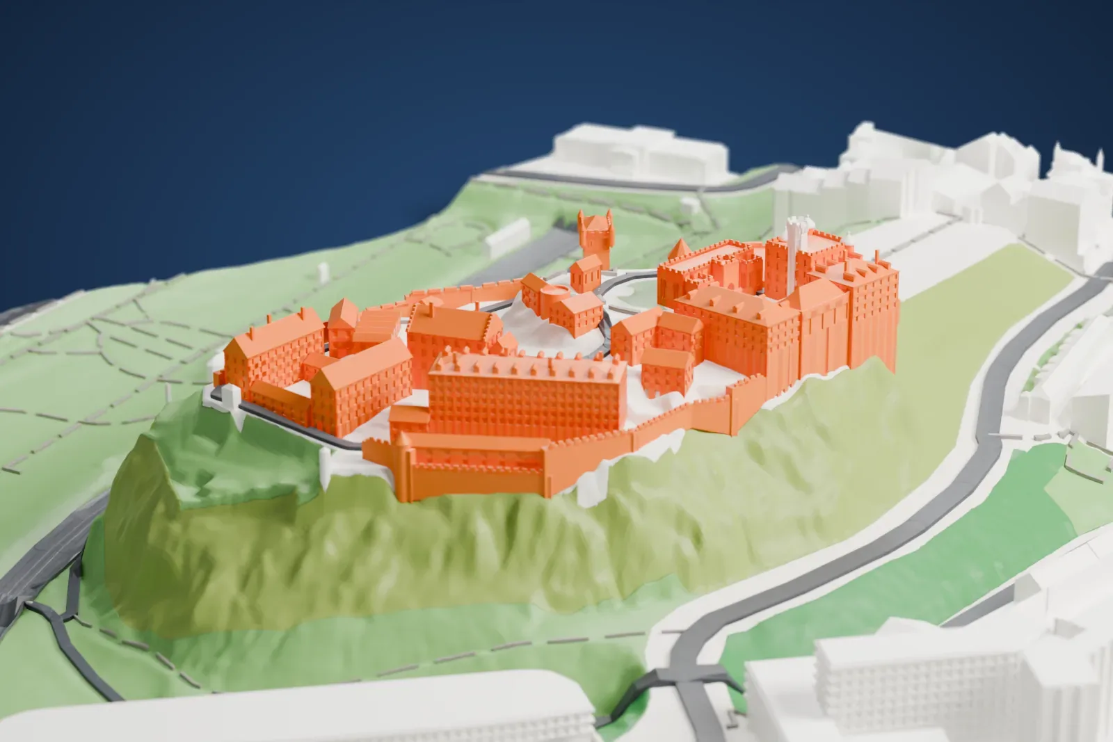 A white 3D print of Edinburgh Castle, a crowded cluster of towers, halls and battlemented walls on a steep crag, surrounded by green parkland and the buildings of the city.