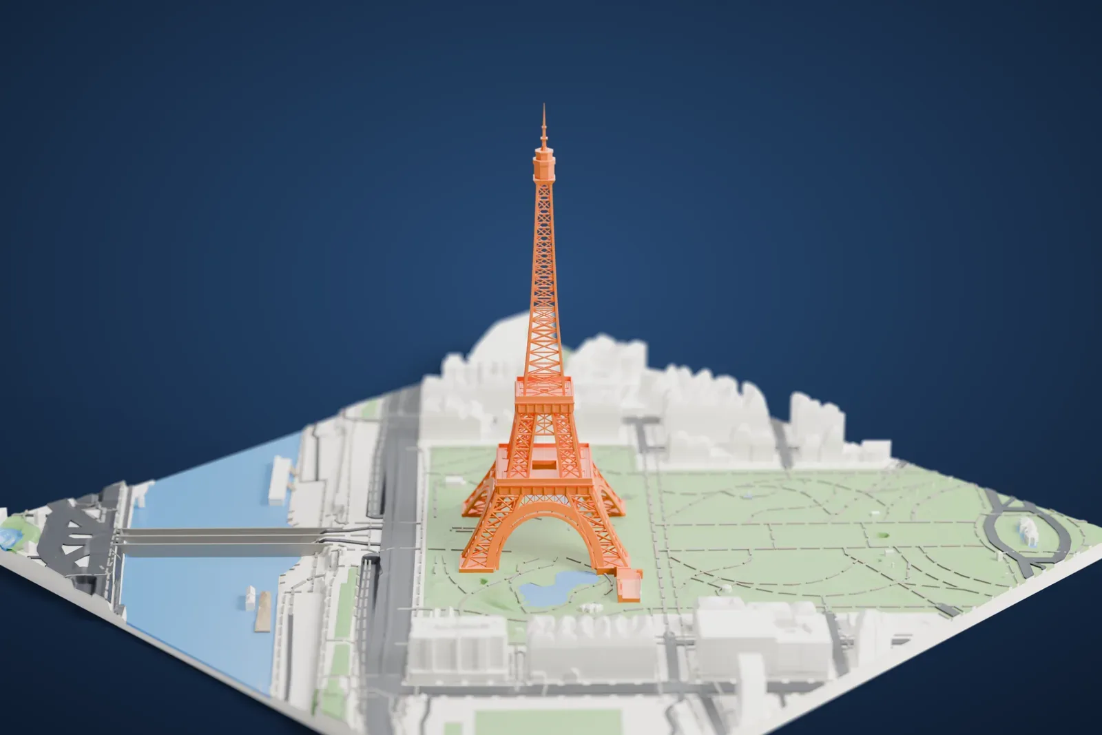 A white 3D print of the Eiffel Tower standing on the Champ de Mars, with park paths and small ponds around it and a river with bridges along one side.