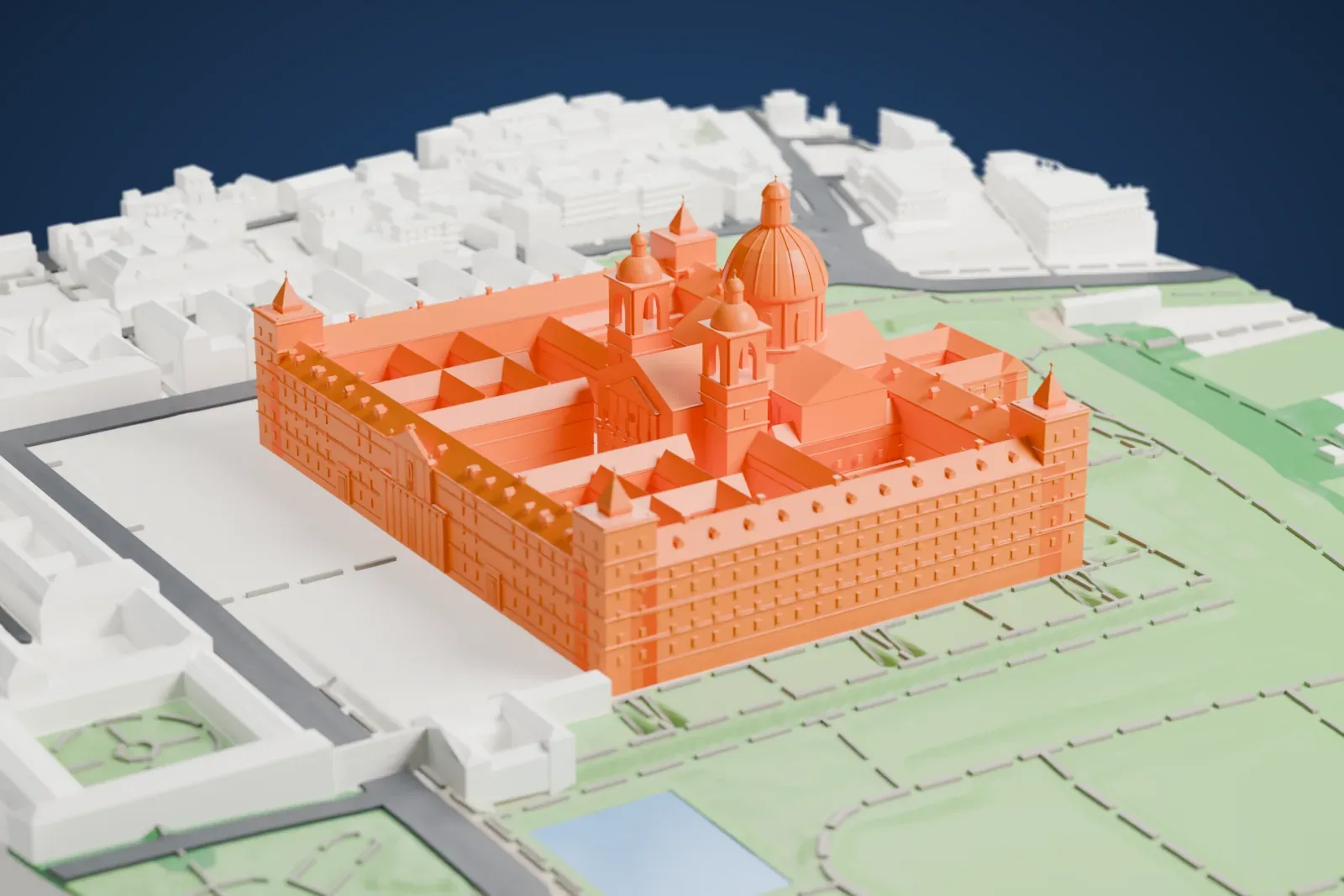 A white 3D print of the El Escorial complex with its central dome and courtyards, surrounded by paths, open grounds, and nearby buildings.
