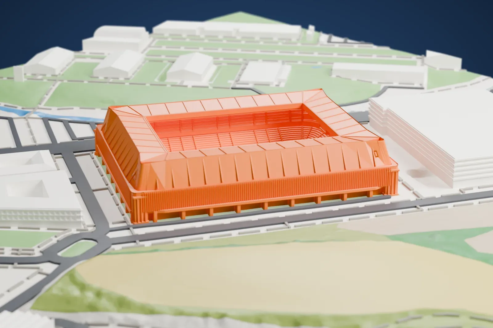 A white 3D print of El Sadar Stadium, a rectangular box with a raking roof ring around a rectangular opening and a colonnade at ground level, among the surrounding city.