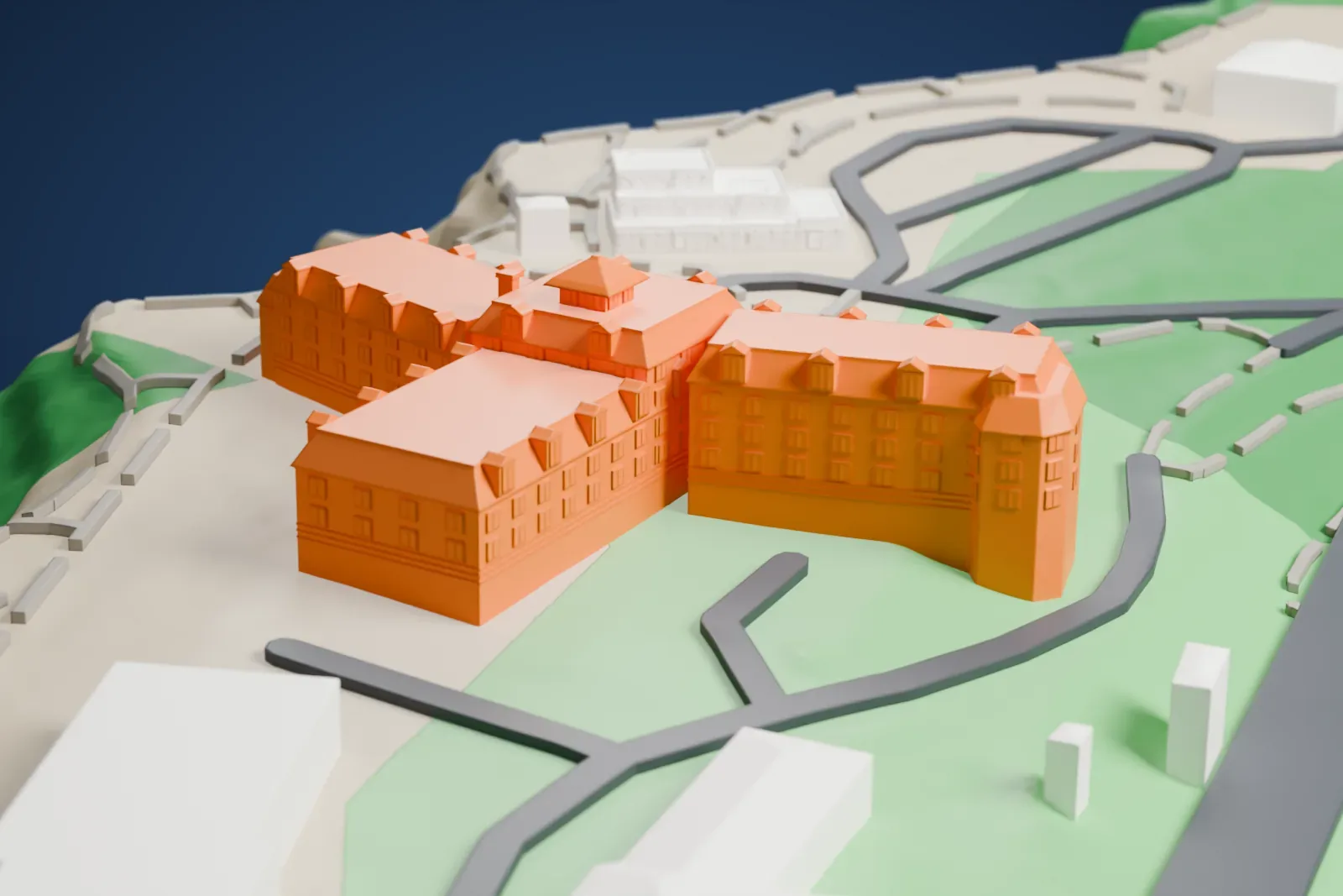 A white 3D print of El Tovar Hotel, a branching lodge with dormers and a pyramid-roofed turret, set on sloping ground beside curving roads and green areas.