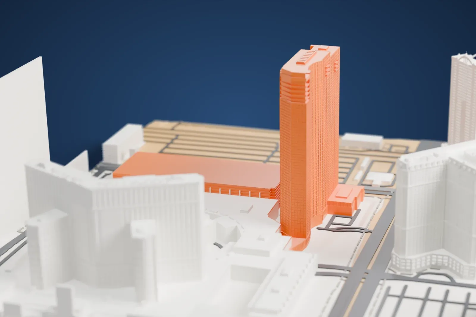 A white 3D print of Elara, a tall slab tower beside the Planet Hollywood resort and other large buildings, with wide roads below.