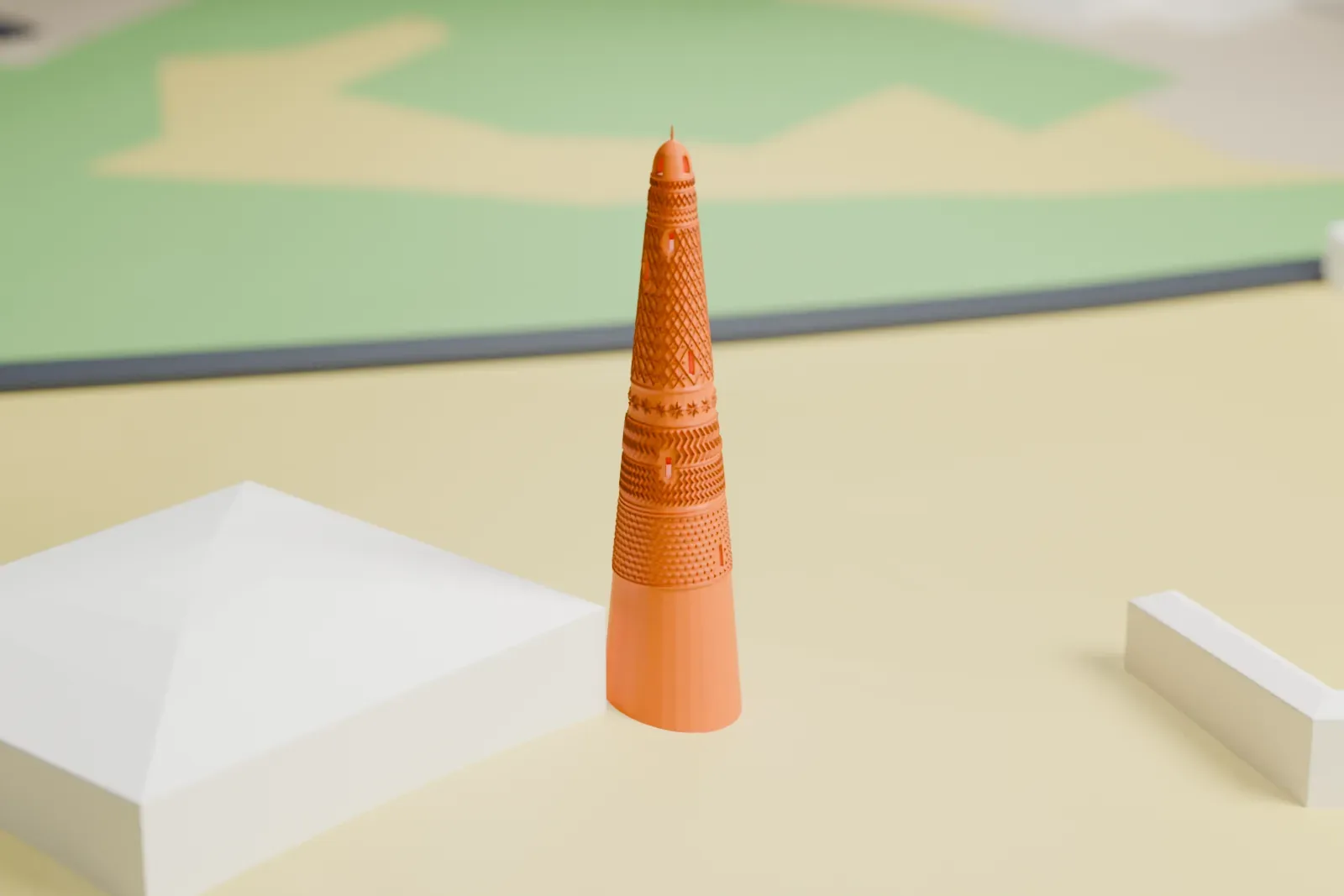 A white 3D print of the Emin Minaret, a tall tapering round tower covered in bands of geometric patterns, standing on open ground beside low buildings.
