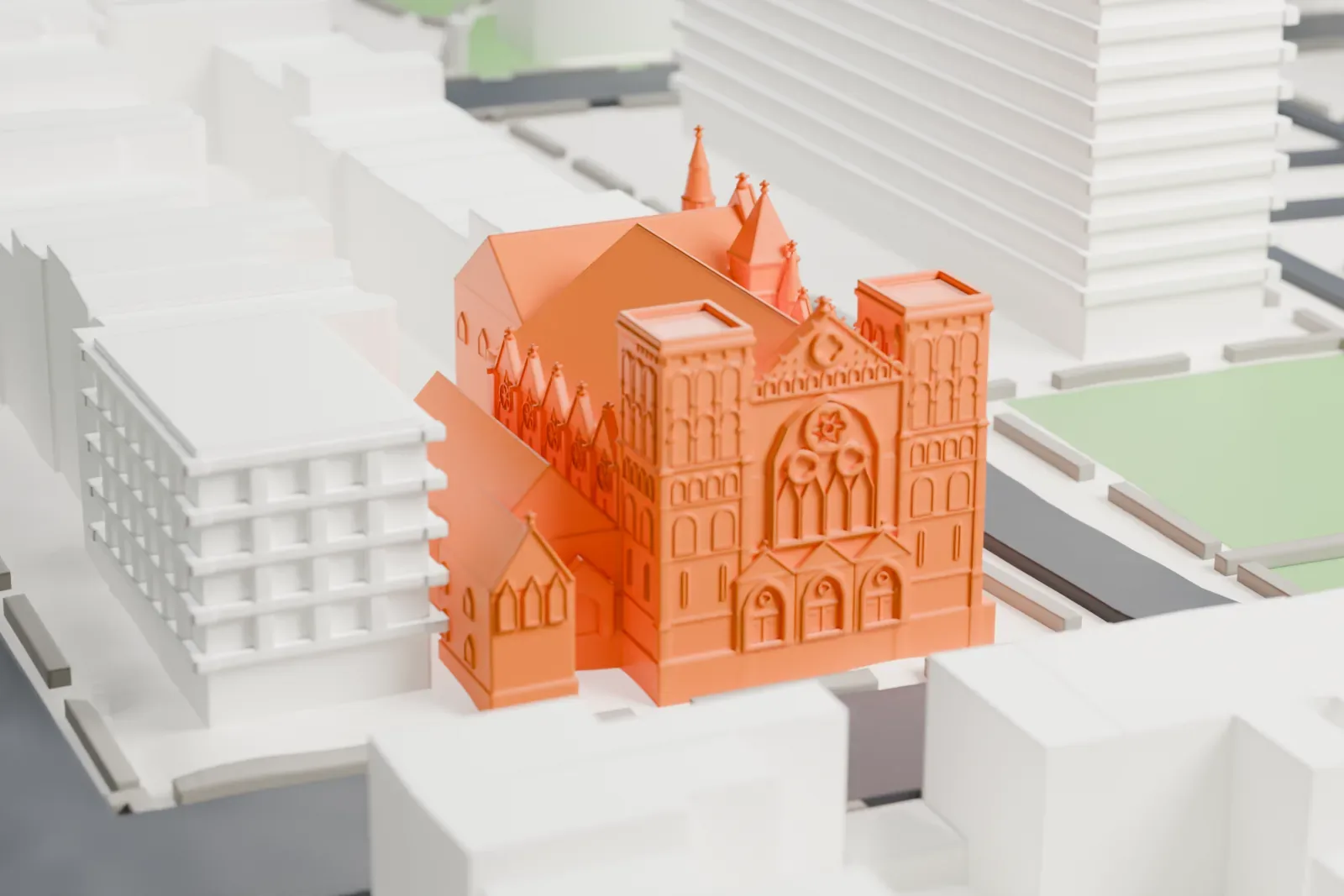 A white 3D print of Emmanuel Baptist Church, a large Gothic-style church with steep roofs, two square front towers and small pinnacles, on a street corner among mid-rise buildings.