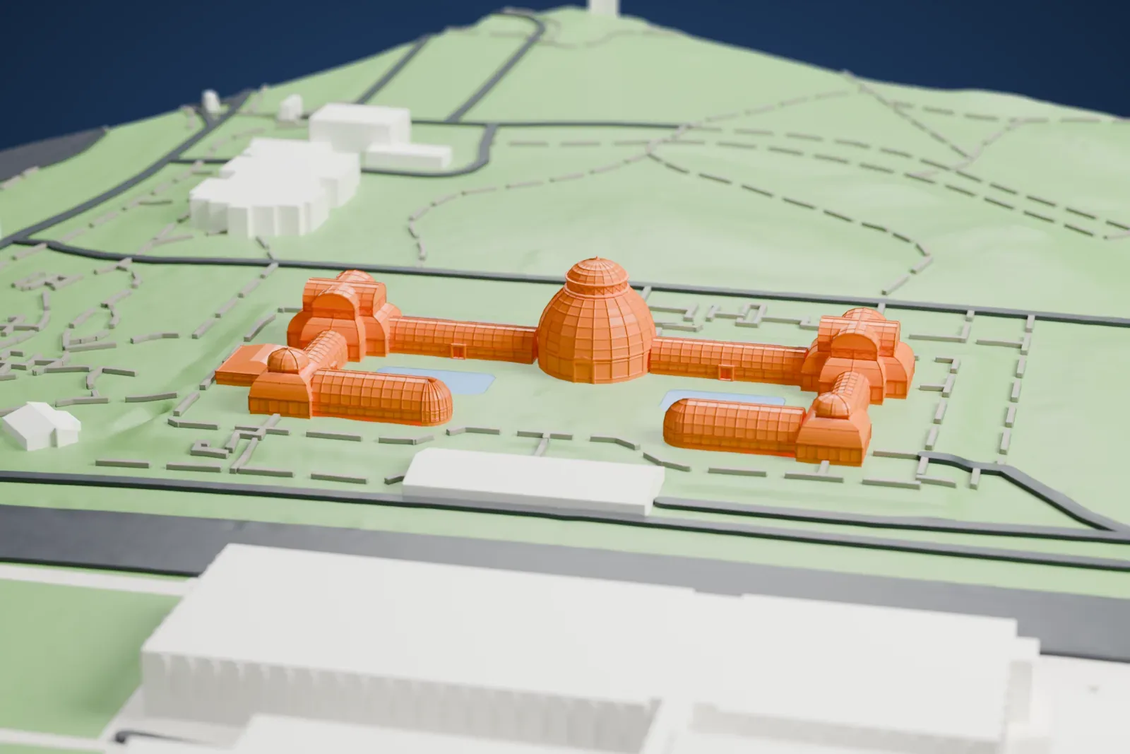 A white 3D print of the Enid A. Haupt Conservatory, a central dome with long wings and small pools, set in green grounds with winding paths.