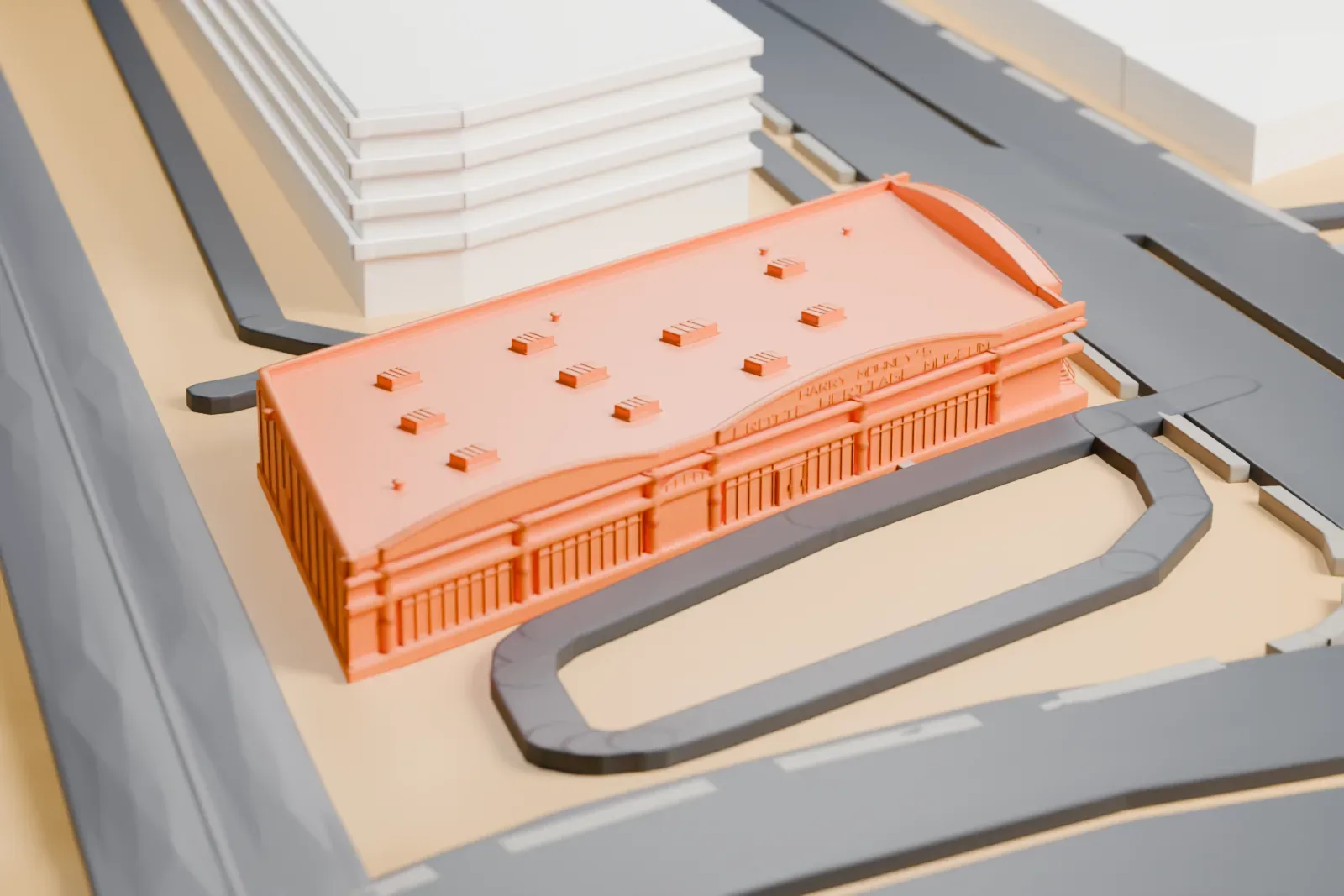 A white 3D print of the Erotic Heritage Museum, a low flat-roofed building with a curved front edge and small rooftop boxes, beside roads and larger buildings.