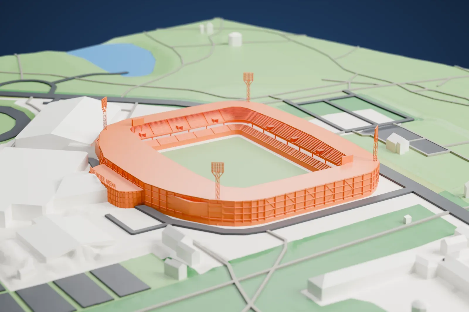 A white 3D print of Esbjerg Stadium, a roofed stadium bowl with four floodlight masts around a pitch, among the surrounding sports grounds and buildings.