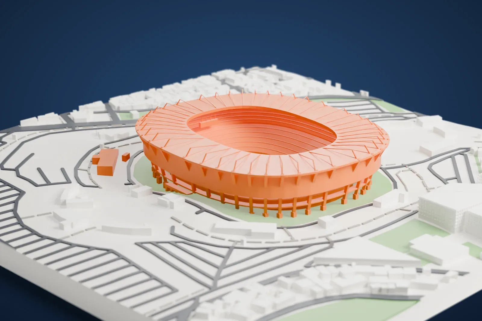 A white 3D print of Estadio Azteca, a round stadium bowl with a ribbed roof ring and stepped seating, standing on a green plot among curving roads and buildings.