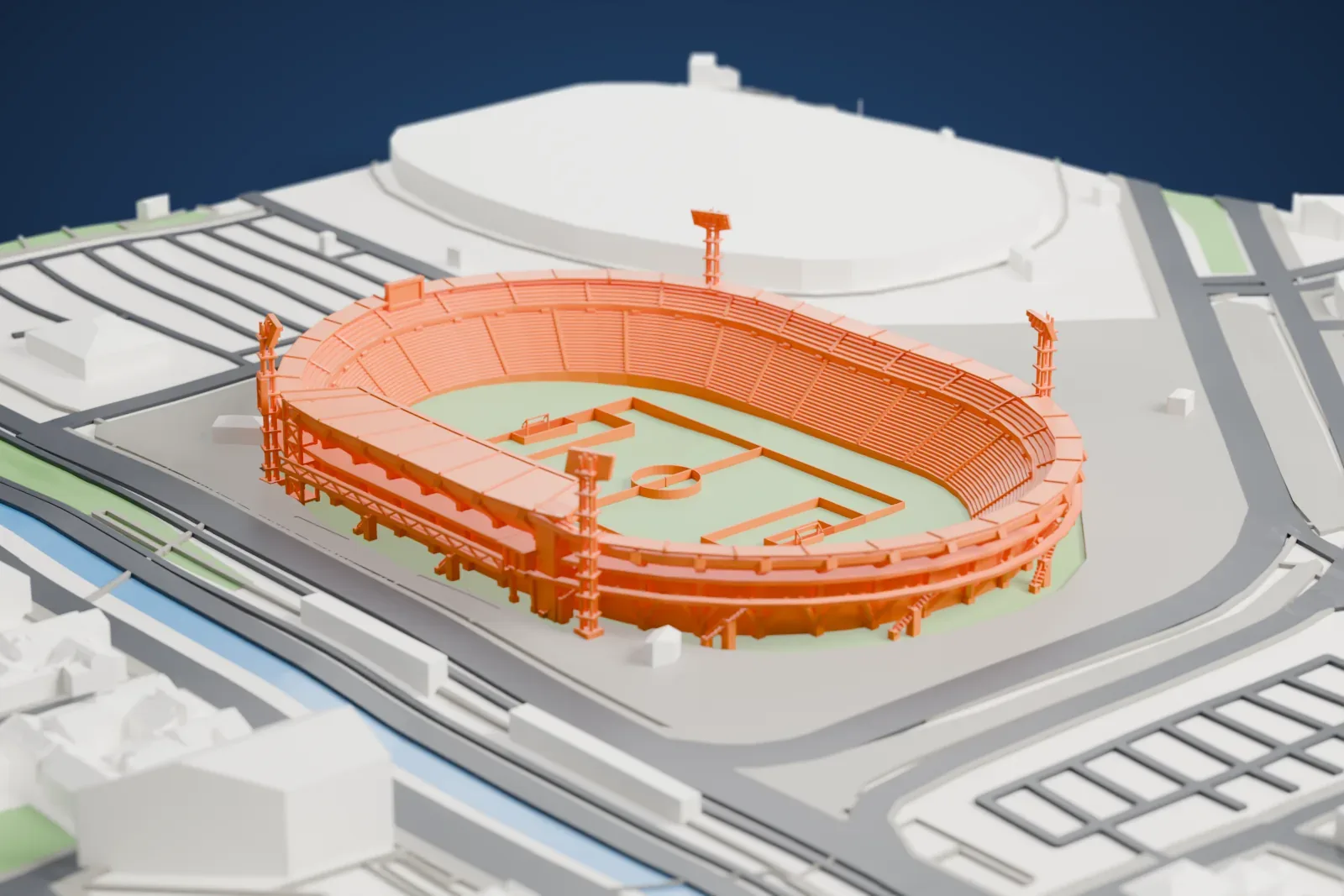 A white 3D print of the Estadio El Campín, an open oval stadium with two seating tiers and four tall floodlight towers, surrounded by city buildings.