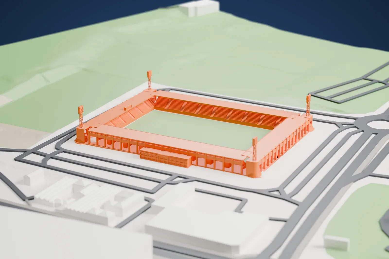 A white 3D print of Estadio El Toralín, a four-sided stadium with corner floodlight masts around a pitch, among the surrounding streets and open ground.
