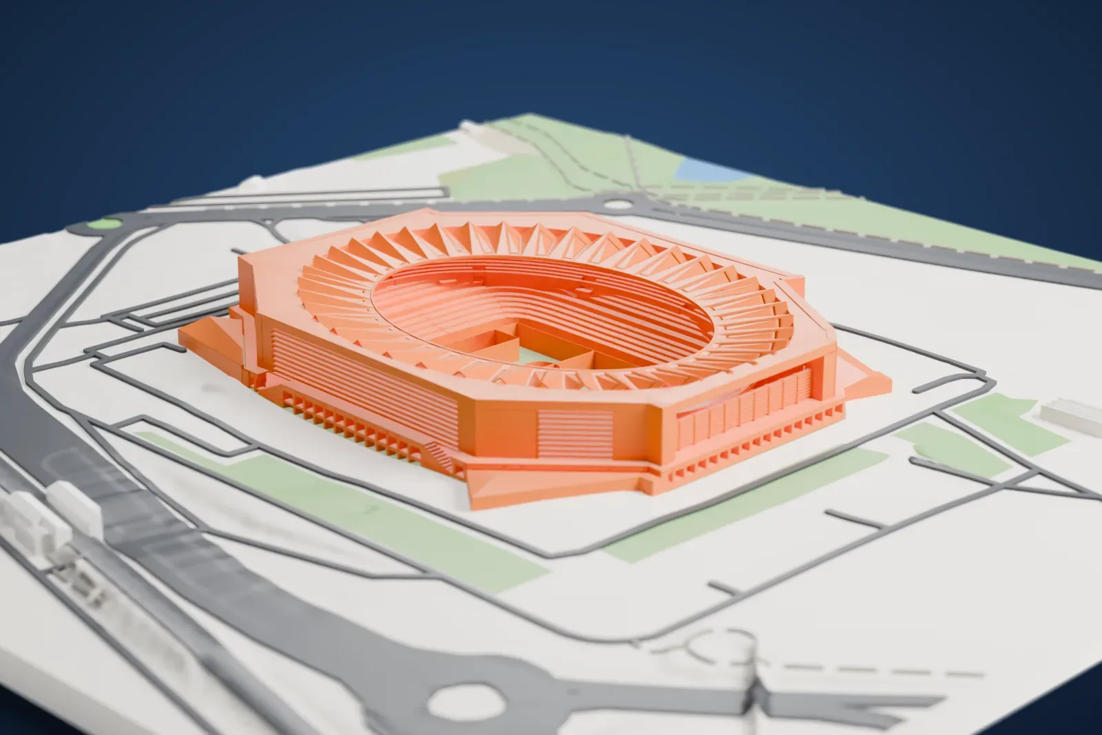 A white 3D print of Estadio La Cartuja, an angular stadium with a ring of angled roof panels around an oval bowl, standing among roads and open ground.