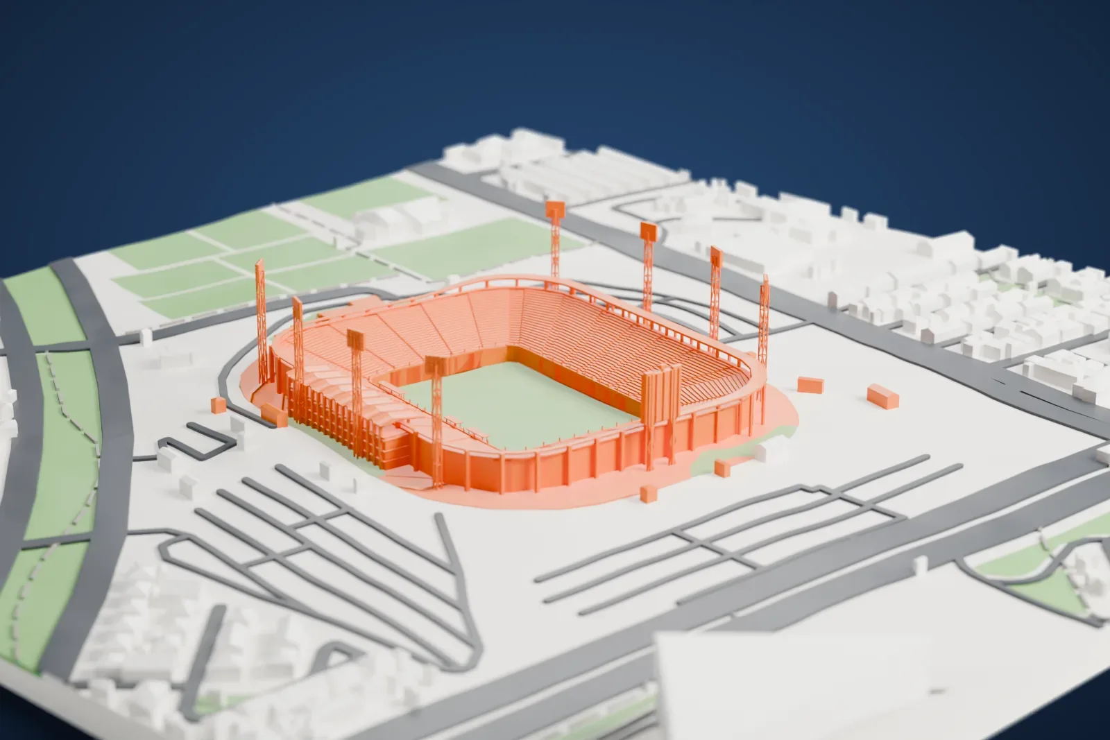 A white 3D print of Estadio Monumental David Arellano, an open stadium bowl with four tall light towers, surrounded by parking areas, roads, green fields and low buildings.