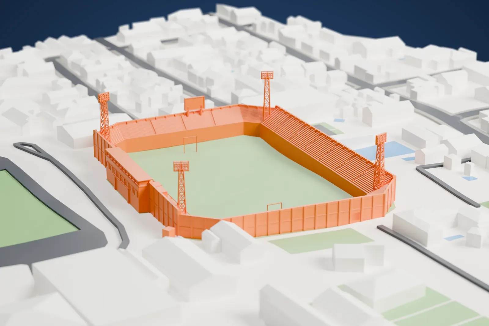 A white 3D print of Estadio Osvaldo Domínguez Dibb, showing its open bowl, four floodlight towers and the city blocks around it.