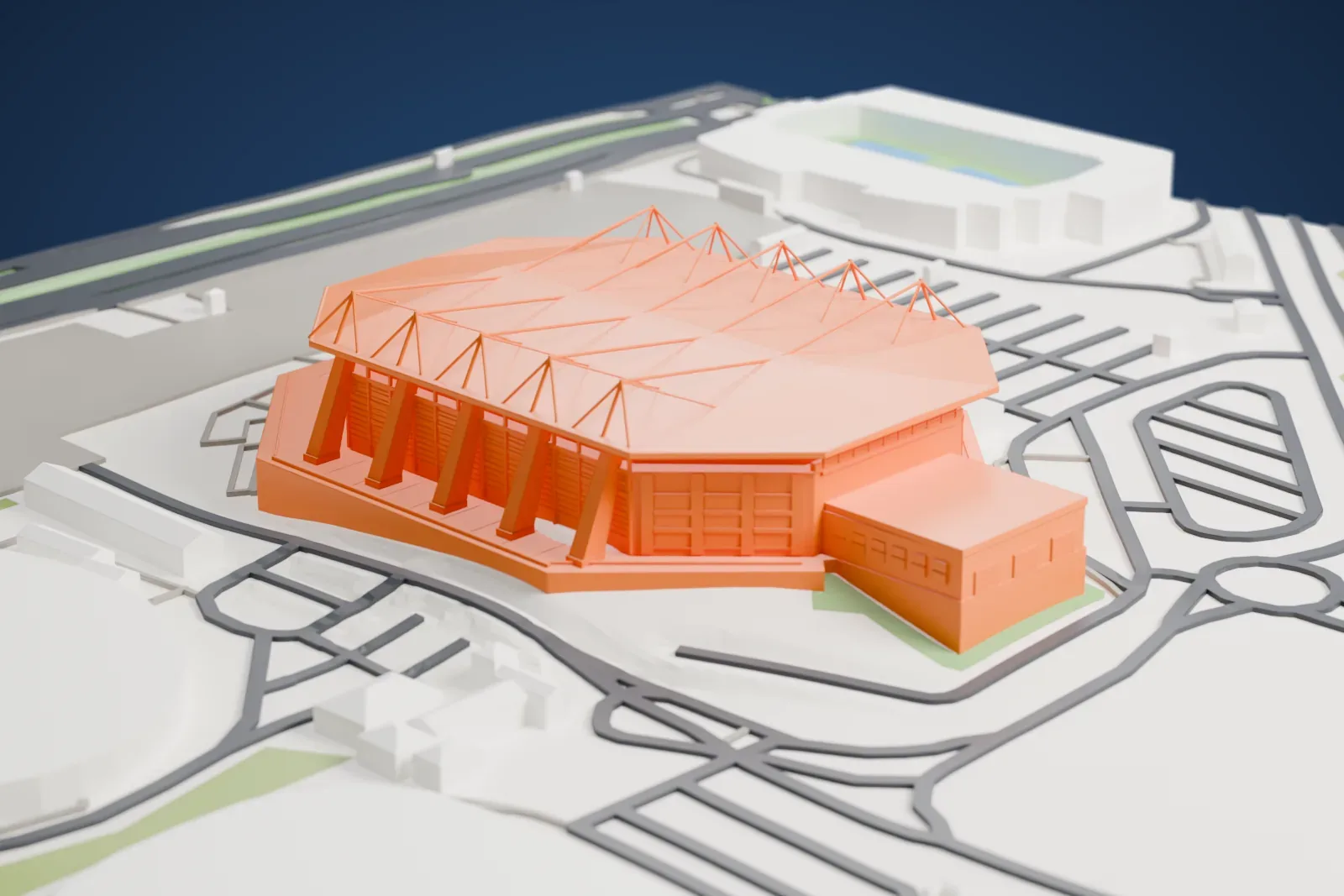 A white 3D print of Farmasi Arena, an elongated arena with a broad roof and open entrance canopy, among surrounding streets and buildings.