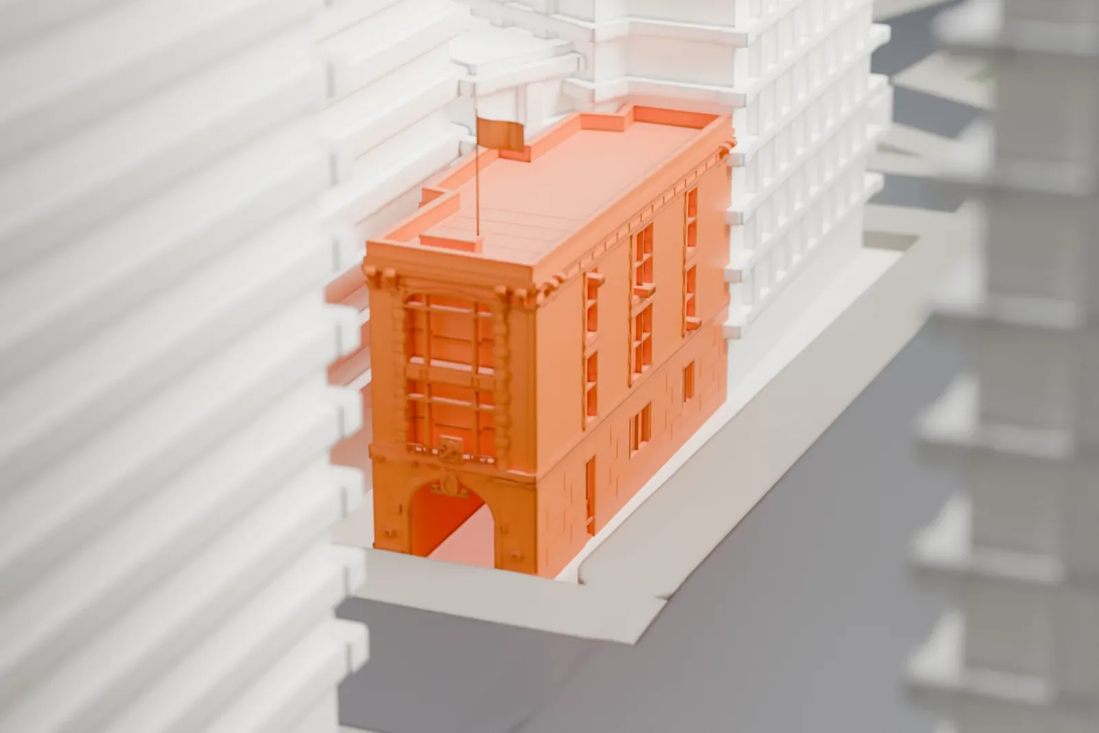 A white 3D print of the Hook & Ladder Company 8 firehouse, a narrow low building wedged between taller buildings beside a street.